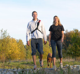 Canvas Print - Junges Paar mit Hund beim Wandern in herbstlicher Natur