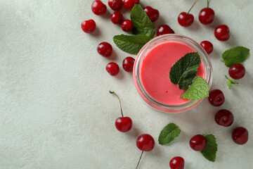 Wall Mural - Glass jar of cherry smoothie and ingredients on white textured table