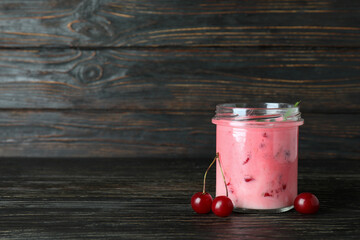 Wall Mural - Glass jar of cherry smoothie and ingredients on rustic wooden table