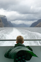 Child on a boat, watching the sea.