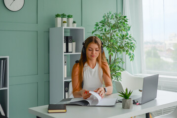 Wall Mural - beautiful young female student is studying at the laptop. freelancer