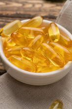 Omega 3. Gold Fish Oil Gel Capsules In Bowl Isolated. Vitamin E.