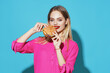 © SHOTPRIME STUDIO - cheerful blonde in a pink shirt hamburger fast food snack blue background