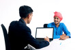 © PRASANNAPIX - Young indian banker giving some information to farmer at office.