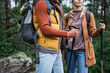 © LIGHTFIELD STUDIOS - cropped view of woman holding hiking sticks and walking with boyfriend in forest