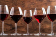 Selection of red wines on wine tasting. Dry, semi-dry, sweet red wine on old wooden table background
