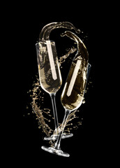 Glasses with sparkling wine and splashes on black background