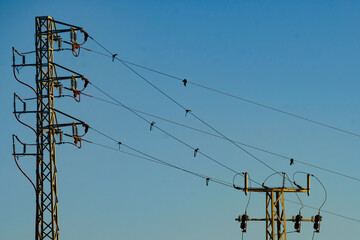 High voltage towers against blue sky