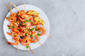 Wall Mural - Grilled Lemon Shrimp Skewers in plate on gray stone background.