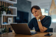 © bnenin - Portrait of a sleepy businesswoman working on laptop.