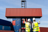 Fototapeta Do pokoju - Engineers are overseeing the transportation of cargo with containers inside the warehouse. Container in export and import business and logistics.