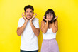 © luismolinero - Young mixed race couple isolated on yellow background covering both ears with hands