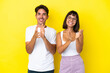 © luismolinero - Young mixed race couple isolated on yellow background applauding after presentation in a conference