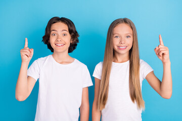 Poster - Photo of two genius kids have idea raise fingers show empty space wear white t-shirt isolated blue color background