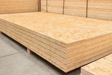 Pressed wooden osb panel. Background texture of wooden OSB board butt ends stacked, close up.