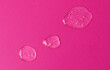 Round big and small drops of white gel with bubbly texture.Jelly texture of antibacterial liquid with bubbles inside.Bright pink background with copy space,advert banner,cosmetics concept.