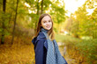 © MNStudio - Adorable young girl having fun on beautiful autumn day. Happy child playing in autumn park. Kid gathering yellow fall foliage.