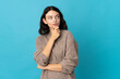 © luismolinero - Teenager Ukrainian girl isolated on blue background having doubts