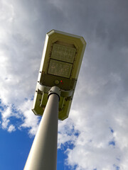 Sticker - Vertical shot of a street lamp on a cloudy sky background