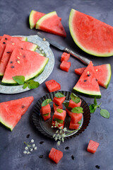 Wall Mural - Vertical view of a gray table with slices of ripe watermelon. Still life