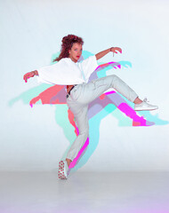 Wall Mural - Dancing mixed race young girl in colourful light. Female dancer performer showing hip hop expressive dance
