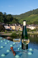 White quality riesling wine served on old bridge across Mosel river with view on old German town in sunny day