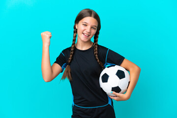 Little caucasian girl isolated on blue background with soccer ball celebrating a victory