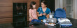 © David Pereiras - Mother explaining to her daughter how to prepare an emergency backpack in the kitchen