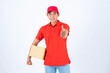 © suphaporn - Delivery man employee in red cap blank t-shirt holding a parcel box And he used hand to give a thumbs up like icon isolate on white background ,showing company excellence , transporting goods employee