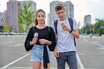 Wall Mural - Happy talking couple of teenagers walking together in the city