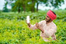 Indian Farmer Using Smartphone At Agriculture Field.