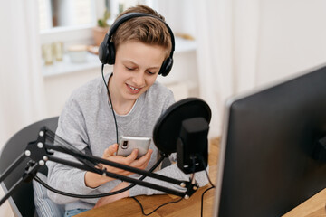 Wall Mural - Young boy recording a podcast at a computer