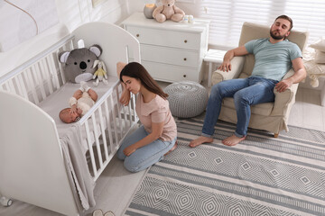 Wall Mural - Tired young parents and their baby sleeping in children's room