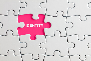 the word identity written on pink missing puzzle piece. individuality, difference or diversity