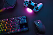 © Martin Piechotta - Top down view of various gaming accessories laying on table. Colorful illuminated devices.