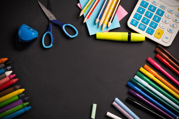 Frame with school supplies on Blackboard background.