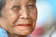 © nuttapon - close-up wrinkled old Asian woman's face was smiling happily.Concept: happiness and hope