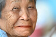 © nuttapon - close-up wrinkled old Asian woman's face was smiling happily.Concept: happiness and hope