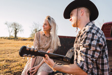 Couple With Guitar Sitting In Vintage Pickup Truck