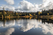 reflection of autumn forest and clouds in lake