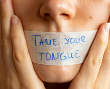 Tame (control) Your Tongue Handwritten Bible Quote On Plaster On Woman's Lips. Christian Teaching Power Of Mouth Words.  A Closeup.