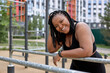 © Roman - Portrait of young afro american woman in black tracksuit posing at camer, have rest. excited black woman overweight lady in black trendy tracksuit, resting after sports activities in sports ground