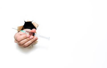 Wall Mural - Hand holding a syringe with a needle and liquid substance inside. could be vaccine or drugs. Isolated on white with copy space.