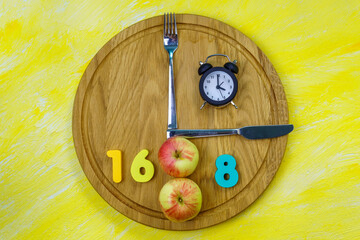 Intermittent Fasting 16:8. Healthy eating lifestyle with popular health and fitness trend. Flat lay. Yellow background