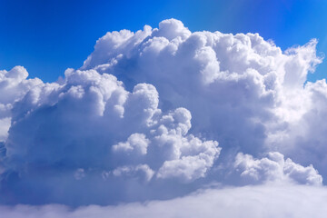 Wall Mural - A large white cloud against the blue sky, a view from the plane window. Space for copying text