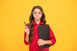 © Olena - serious teenager girl in protective glasses making notes in folder with documents, study