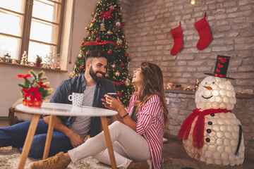 Canvas Print - Couple drinking coffee at home on Chirstmas morning