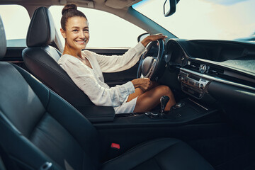 Wall Mural - Pleased lady looking at camera from driver seat