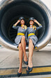 Beautiful stewardesses in uniforms sitting cross-legged inside the turbofan engine