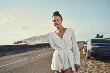 Wall Mural - Female in tunic signaling drivers to pick her up